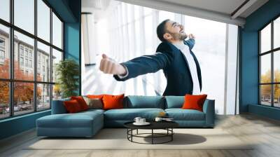 excited young caucasian businessman celebrate victory cheerful in modern office Wall mural